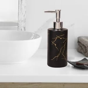 Matte black marble design soap dispenser with gold veining and silver pump on a wooden vanity next to a white sink - Trenducts Pakistan
