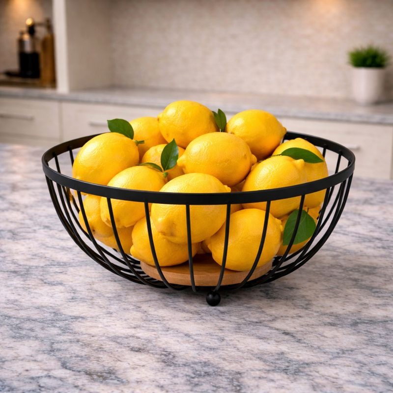 "Trenducts metallic wire fruit basket with solid oak wood base on a marble countertop."

"Minimalist matte black metal and wood fruit bowl for modern kitchen organization in Pakistan."