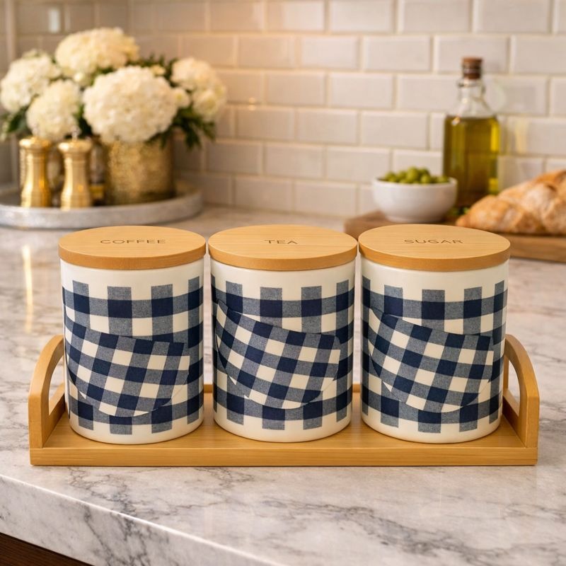 Three checkered ceramic jars for tea, coffee, and sugar with bamboo lids sitting on a bamboo tray on a kitchen counter - Trenducts Pakistan